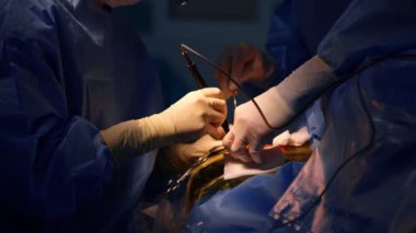 Karanlık operasyon odasında nöroşirürji prosedürü. Doktorların eldivenli elleri modern aletleri kullanırlar..