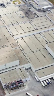 Sahadaki büyük bir fabrikanın çatısında. Endüstriyel kompleks. Yeşil alana yakın büyük imalat. Hava görüntüsü. Dikey video