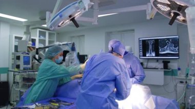 Cerrahi kadın hemşire iki beyin cerrahına ameliyatta yardım ediyor. Doktor aletleri doktorlara verir..