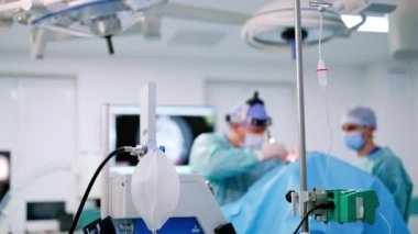 Valf maskesi takın ve ameliyathaneye bırakın. Doktor ameliyatı arka planda bulanık bir şekilde gerçekleştiriyor..