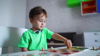 Masada oynayan Kafkasyalı bir çocuk var. Tatlı çocuk bulmacaları çözmekle meşgul. Bulanık arkaplan.