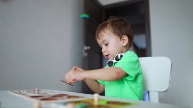 Sevimli erkek bebek oyununa odaklanmış. Bulmacalarla oynayan sevimli çocuk. Düşük açı görünümü.