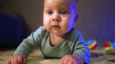 Büyük mavi gözleri olan sevimli sarışın çocuk. Sevimli yanaklı bebek, etrafa ilgiyle bakıyor. Kapat..