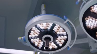 Modern ameliyathane tavanında yuvarlak lambalar açıldı. İşlemler için aydınlatma ekipmanı kapat.