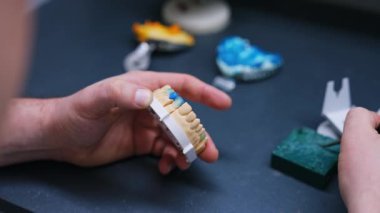 Erkek eller takma diş modelini tutar. Profesyonel, diş implantasyonu için bir araç kullanır. Kapat..