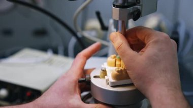 Erkek eller alçı protez üreten makineyi çalıştırıyor. Kapatın. Diş hekimi kavramı.
