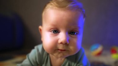 Güzel beyaz, iri gözlü bir bebek. Kameraya bakan sevimli bir bebeğin yüzü. Kapat..