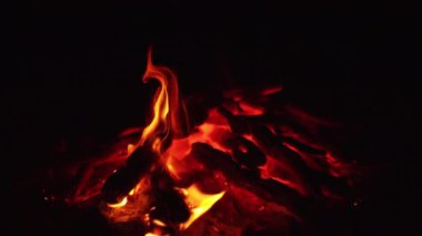 Şenlik ateşinde yanmış odun. Yığının içinde yanan güzel közler. Kapat..