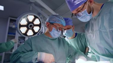 Cerrahi ekip ameliyat alanına dikkatle bakıyor. Beyin cerrahları modern cerrahi odasında çalışır..