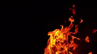 Alevler, duman ve küçük kıvılcımlar uçuşuyor. Karanlık gecede yanan şenlik ateşi. Kapat..