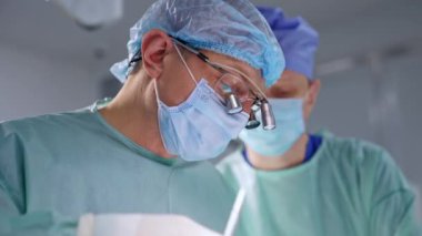 Maske ve cihaz gözlüğü takan beyaz bir doktor. Operasyonda çalışan bir cerrahın portresi..