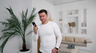 Kaslı beyaz erkek, ışık odasında duruyor. Adam birini arar ve konuşmaya başlar..