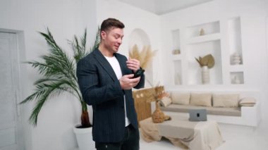 Ceket giyen beyaz adam akıllı telefonunda bir numarayı çeviriyor. Erkek telefonda bir mesaj yazıyor..