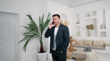 Ceket giyen bir adam telefonda konuşuyor. Akıllı telefonda arkadaşça bir konuşma, bolca kahkaha..