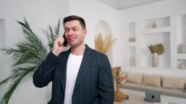 Telefonda konuşan iyi huylu bir adam. Beyaz ceketli adam evinden müşterilerle iletişim kuruyor..