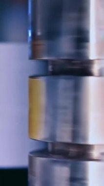 Bebek bezi üretim fabrikası. Parlak metal paten etrafta dönüyor. Arka plandaki bulanık kuyu. Kapatın. Dikey video