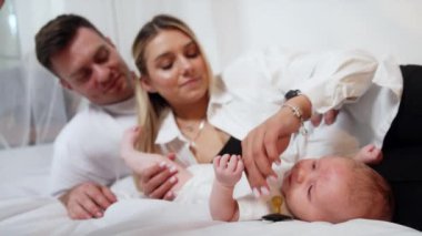 Sevimli yeni bir aile. Mutlu, genç bir aile yeni doğmuş, sevgi dolu kucaklaşmalar.