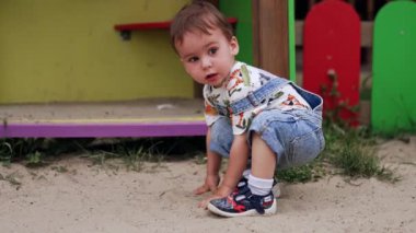 Oyun parkındaki mutlu çocuk. Küçük çocuk oyun alanında oynuyor..