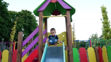 Renkli oyun parkında küçük bir çocuk. Parktaki küçük neşeli çocuk..