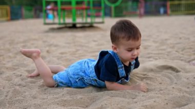 Su sıçratmayla oynuyor. Nehir kıyısında oynayan komik çocuk..