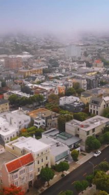 Gündüz vakti modern San Francisco, Kaliforniya 'nın güzel mimarisi. Şehrin üzerinde beyaz bir sis var. Üst Manzara. Dikey video