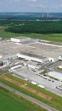 Doğa arasındaki sanayi bölgesi. Kırsalda büyük bir üretim tesisi. Sahada modern üretim. Hava görüntüsü. Dikey video