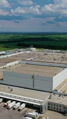 Doğadaki üretim bölgesi. Çevresi yeşil manzarayla çevrili devasa endüstriyel kompleksi olan modern bir bölge. Hava görüntüsü. Kamera geri gidiyor. Dikey video