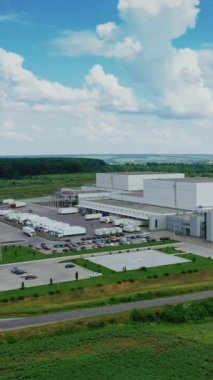 Taşrada modern bir fabrika. Yeşil doğa arasında endüstriyel alana panoramik bir bakış. Yazın sahada büyük üretim. Dikey video