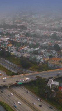Yoğun trafiği ve hareketli caddeleri olan bir panorama. San Francisco manzarası sisli. Hava görüntüsü. Dikey video