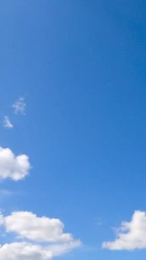 Güneşli bir gün, parlak güneşle aydınlatılmış beyaz bulutlarla kaplı açık bir gökyüzü. Güzel, yumuşak bulutlu, alçak açılı manzara. Zaman ayarlı. Dikey video