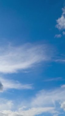 Beyaz yumuşak bulutlar ufukta hızla hareket ediyor. Bulut oluşumu düşük açı görünümü. Zaman ayarlı. Dikey video