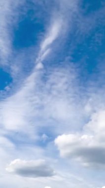 Çevrede dönüşen birkaç tür bulut. Mavi gökyüzü kümülüs bulutlarıyla kaplı. Zaman ayarlı. Dikey video