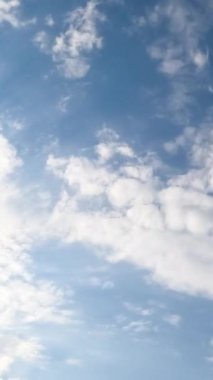 Atmosferde dönen bulutların yavaş dönüşümü. Gökyüzünü kaplayan beyaz bulutlar alçak açı görüşü. Zaman ayarlı. Dikey video