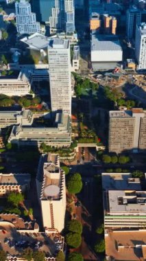 Los Angeles şehir merkezinden yükselen güneş ışığı. Metropolis yollarında hava manzaralı çılgın bir trafik var. Dikey video