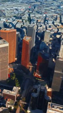 Güneşli gökdelenler şehir panoramasına gölge düşürüyor. Havadan bakıldığında Los Angeles 'ın çeşitli mimarisi inanılmaz. Dikey video