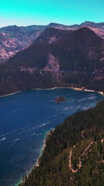 Sierra Nevada dağlarıyla çevrili Tahoe Gölü 'nün muazzam manzarası. Mavi gökyüzünün arka planında çarpıcı vahşi yaşam manzarası. Dikey video
