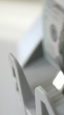 100 dolarlık banknotlar para makinesinde çabucak döndü. Bankalarda para birimi hesaplaması için ekipman. Kapatın. Dikey video