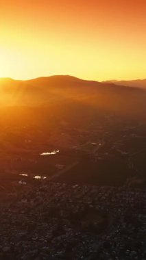 Güneşin batışındaki resimli Napa, Kaliforniya, ABD manzarası. Dağların ve turuncu gökyüzünün arka planında inanılmaz bir şehir. Dikey video