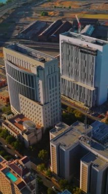 Sacramento şehir merkezinin çağdaş mimarisi. Güneşli bir günde hareketli trafik olan şehrin güneşli manzarası. Dikey video