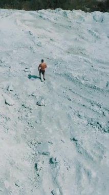 Kardiyo eğitimi, üst düzey. Doğanın dikey videosunda koşan sportif adamın havadan görünüşü