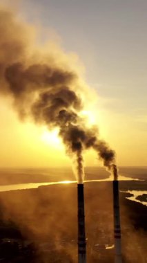 Endüstriyel borulardan duman çıkıyor. Fabrika borusunun tepesi dikey video ile yükseliyor.