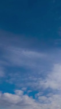 Yumuşak ışık bulutları ufukta hızla akıyor. Ağır gri bulutlar yumuşak bulutları değiştiriyor. Düşük açı. Zaman ayarlı. Dikey video