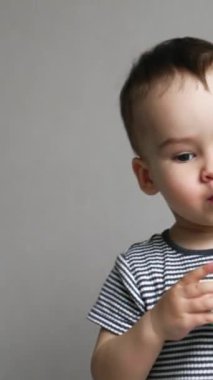 Tatlı çocuk elinde oyuncakla odanın önünden geçiyor. Küçük çocuk evin etrafında dolanıp etrafa bakıyor. Düşük açı. Dikey video