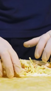 Şef pita ekmeği hazırlıyor. Profesyonel aşçı pidenin içine peynir ve doğranmış salatalık koyuyor. Fast food. Kafkas mutfağı. Yakın plan. Dikey video