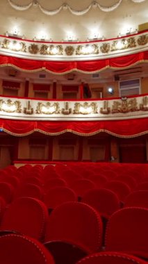 Canlı kırmızı opera binasının içi. Klasik tiyatroda boş kadife koltuklar ve katlar. Kilitleme yüzünden koridorda kimse yok. Dikey video