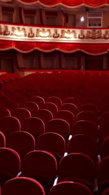 İnsansız çok güzel bir tiyatro. Klasik opera binasında boş kırmızı sandalyeler. Salgın sırasında kapalı bir yer. Dikey video