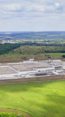 Yazın güzel doğa arasında üretim yapmak. Doğal ortamda modern teknoloji fabrikası. Panoramik manzara. Yukarıdan bak. Dikey video