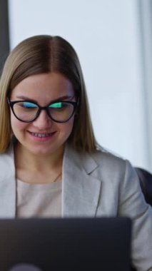 Genç iş kadını bilgisayarında çalışıyor. İş kadını gözlüklerini çıkarır ve hayal kurarak yan tarafa bakar. Dikey video