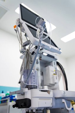 Ameliyathanede tıbbi ekipman var. İki monitörü, tüpleri ve temiz bir konteyneri olan tıbbi bir makinenin yakın çekim görüntüsü..