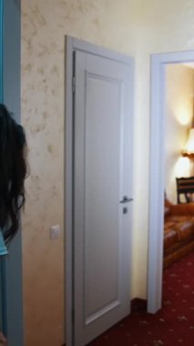 Genç çift eve dönüyor. Yaz tatili sırasında oteldeki odaya bavullu gezgin erkek ve kadın geliyor. Dikey video